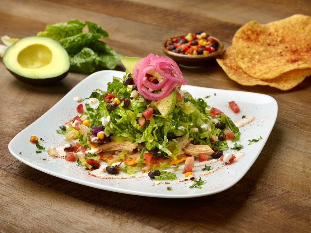 SMOKED CHICKEN TOSTADAS (580 CAL) Pulled chicken, pepper jack cheese and grilled onions on crispy tortillas. topped with avocado, romaine, corn & black bean salsa, pico de gallo, pickled red onions and Mexican crema.